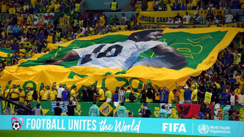 Aficionados de Brasil en las gradas con una pancarta gigante de Pelé durante el partido de fútbol del Mundial Qatar 2022 entre Camerún y Brasil