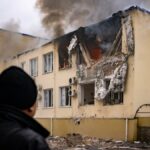 Un trabajador de la empresa pública de agua en Jersón observa como arde la sede tras un ataque ruso
