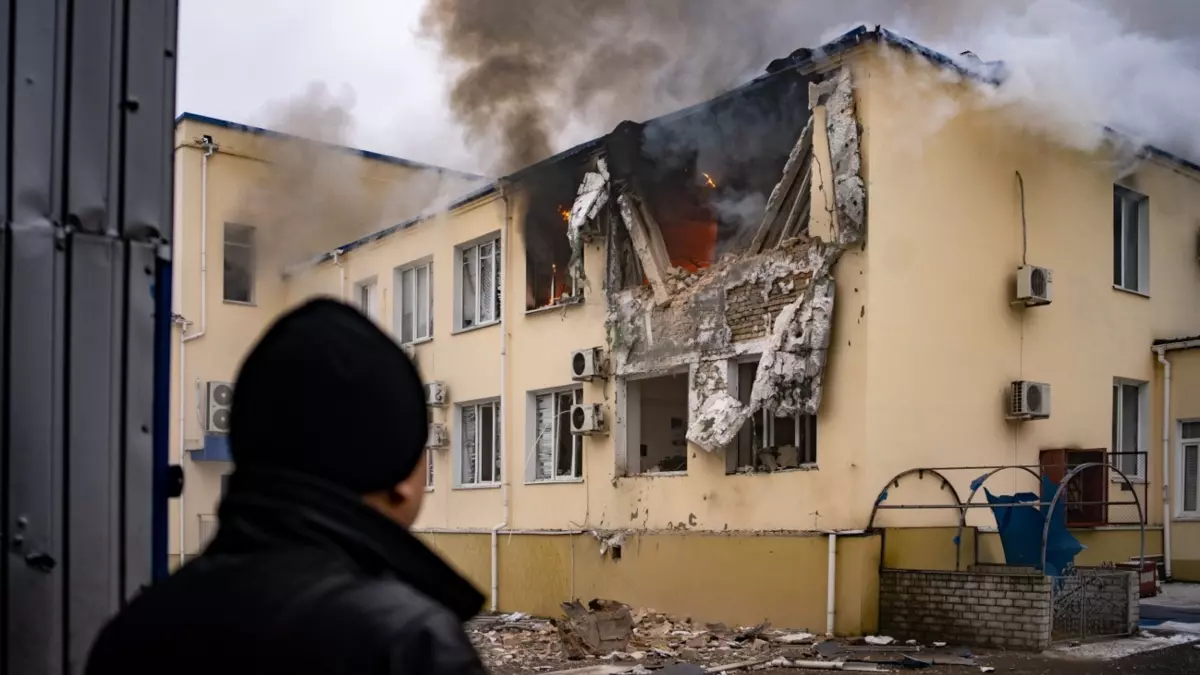 Un trabajador de la empresa pública de agua en Jersón observa como arde la sede tras un ataque ruso