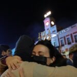 Dos personas se abrazan con la llegada del año 2022 en las Campanadas de Nochevieja, en la Puerta del Sol