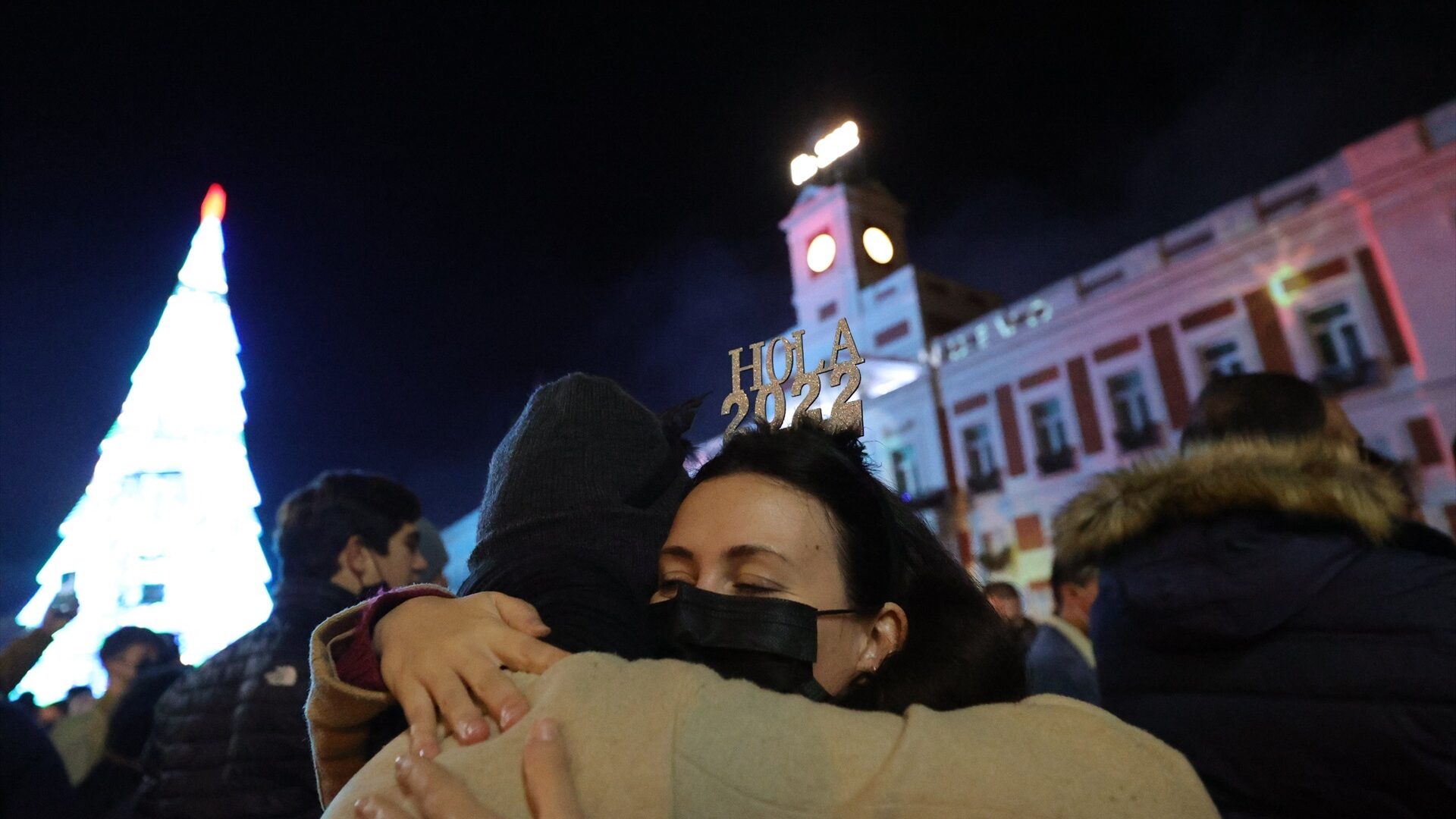 Dos personas se abrazan con la llegada del año 2022 en las Campanadas de Nochevieja, en la Puerta del Sol