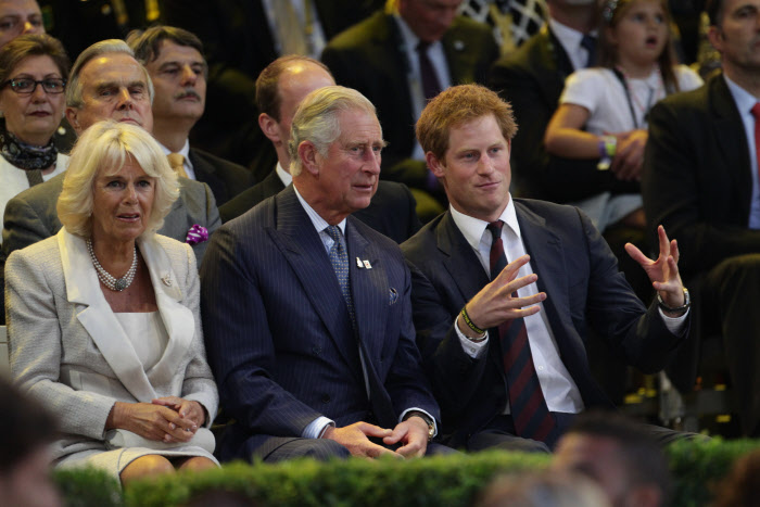 El príncipe Harry, con su padre, el rey Carlos III y su mujer Camilla en 2014