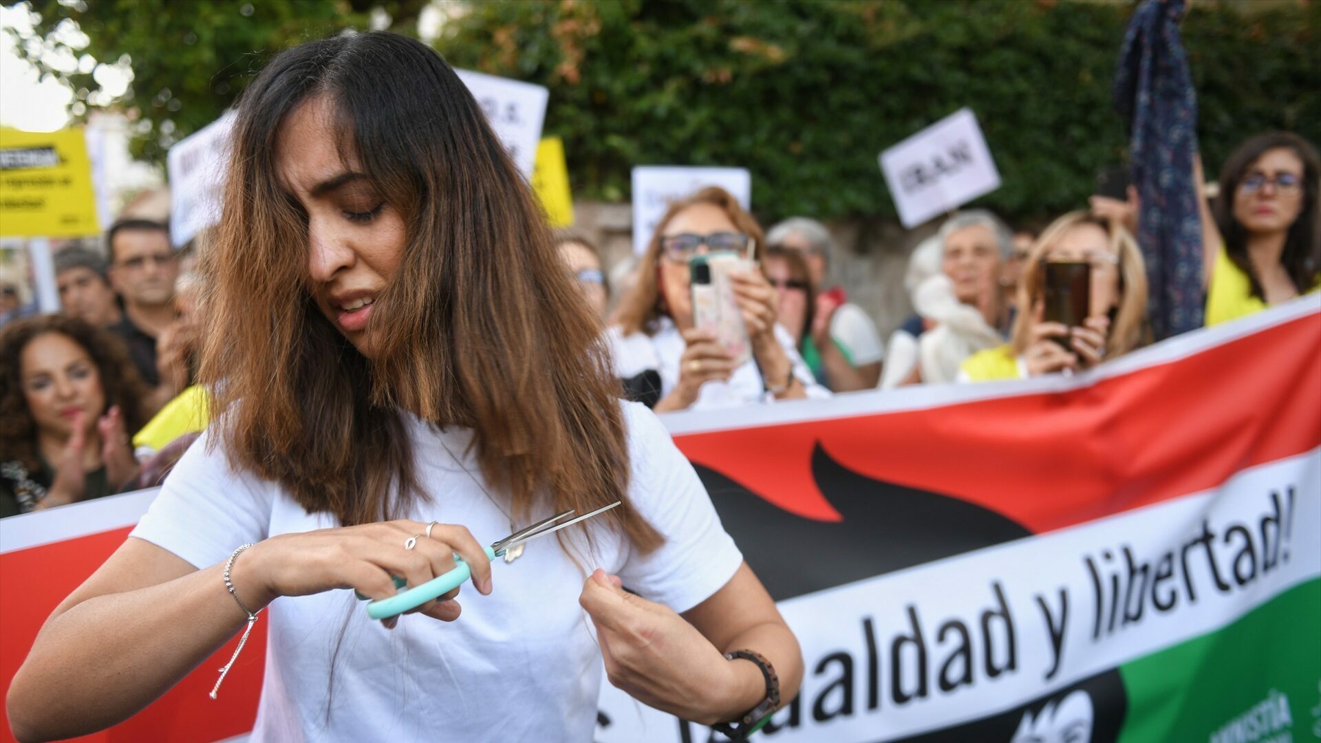 Una mujer se corta el pelo en una concentración contra la muerte de dos mujeres iraníes, en Madrid
