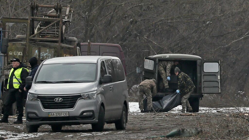 Los miembros del equipo especial mueven el cuerpo de un hombre tras los ataque con misiles en Kiev