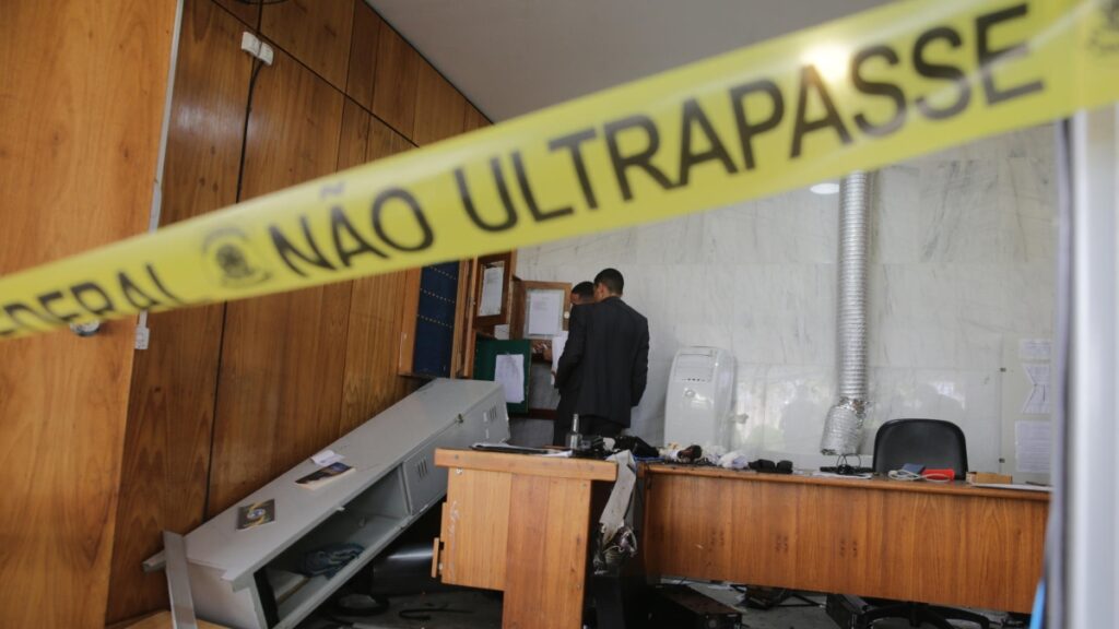 Dos hombres revisan una oficina destrozada al interior del Palacio de Planalto