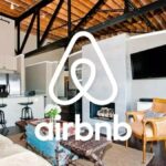 El logo de Airbnb sobre una imagen de una de sus casas