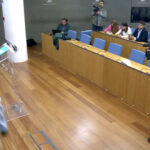 La portavoz de Junts en el Congreso, Míriam Nogueras, aparta la bandera de España durante una rueda de prensa
