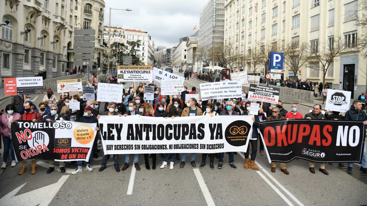 Varias personas, con pancartas en la concentración en apoyo a los afectados por la okupación