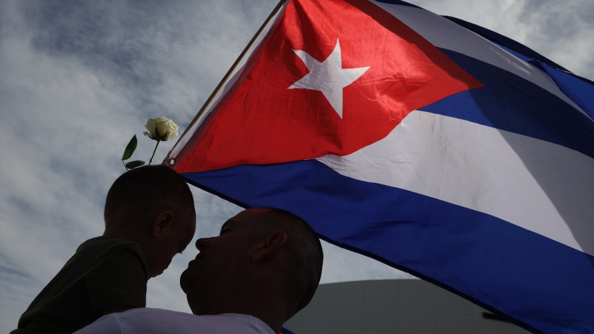 Padre e hijo junto a la bandera de Cuba