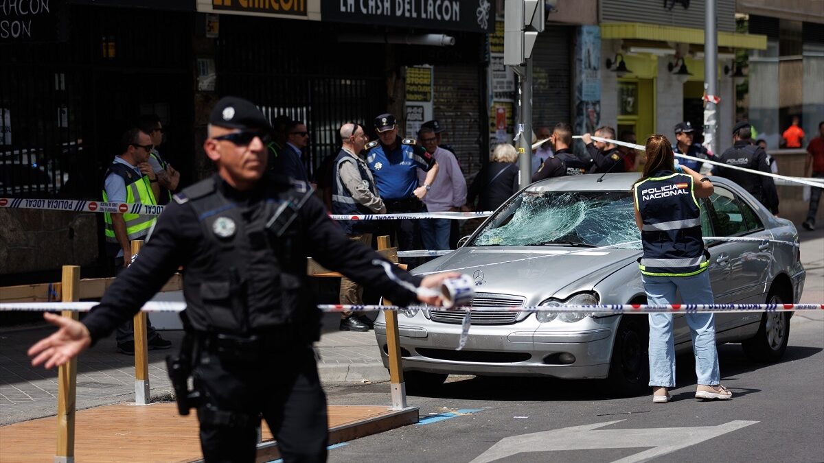Una agente de la policía nacional toma fotografías del coche con el que han sido atropelladas varias personas en el Paseo de Extremadura de Madrid
