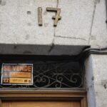 Cartel de una vivienda en venta en el escaparate en el barrio de Almagro, a 12 de marzo de 2023