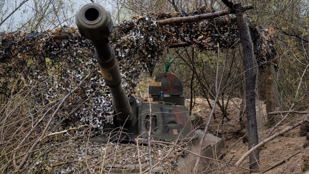 Se ve un obús autopropulsado en una zanja cubierta por una red de camuflaje en la posición ucraniana cerca de Bakhmut.
