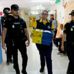 Dispositivo de Seguridad en Colegio León Solá de Melilla en el que varios agentes escoltan a la funcionaria de Correos a la mesa electoral