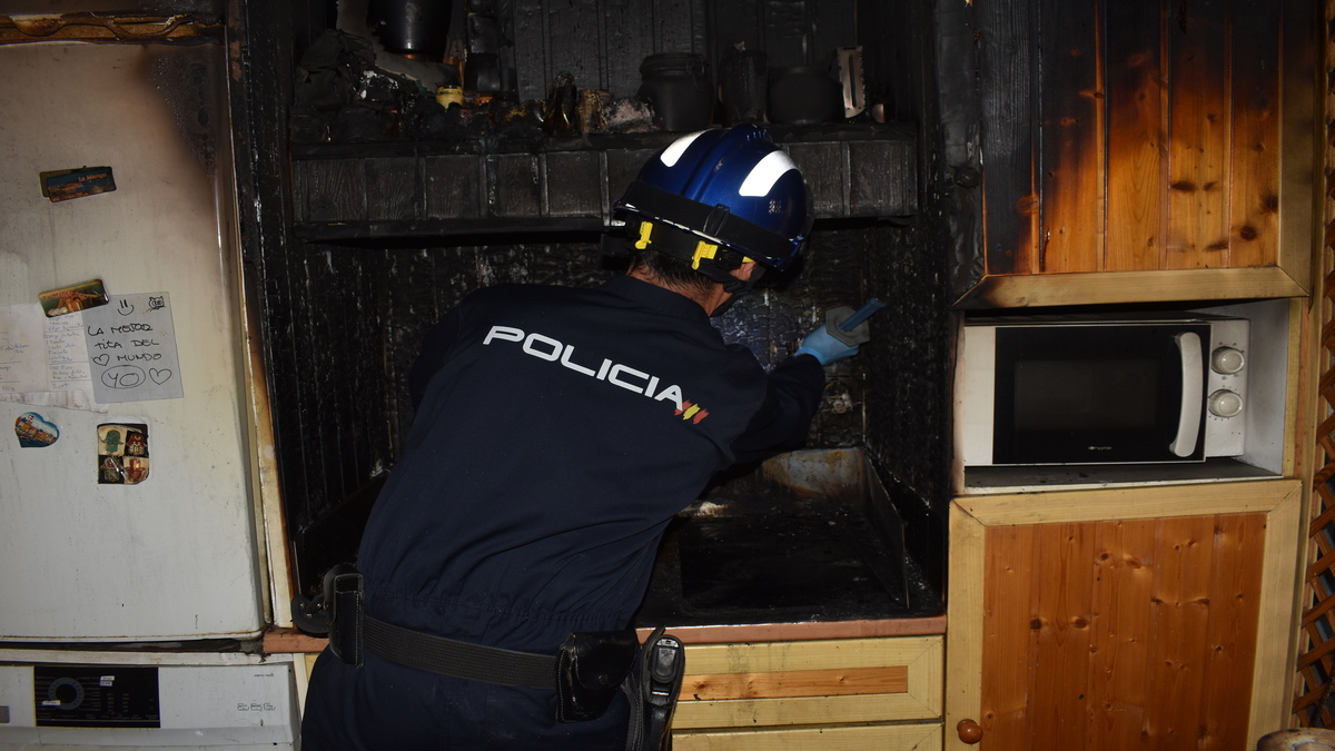 Un agente de la Policía Científica buscando pruebas en un incendio en un piso