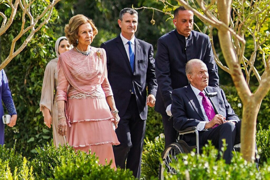 El rey Juan Carlos, en silla de rueda tras acabar la boda del hijo de los reyes de Jordania