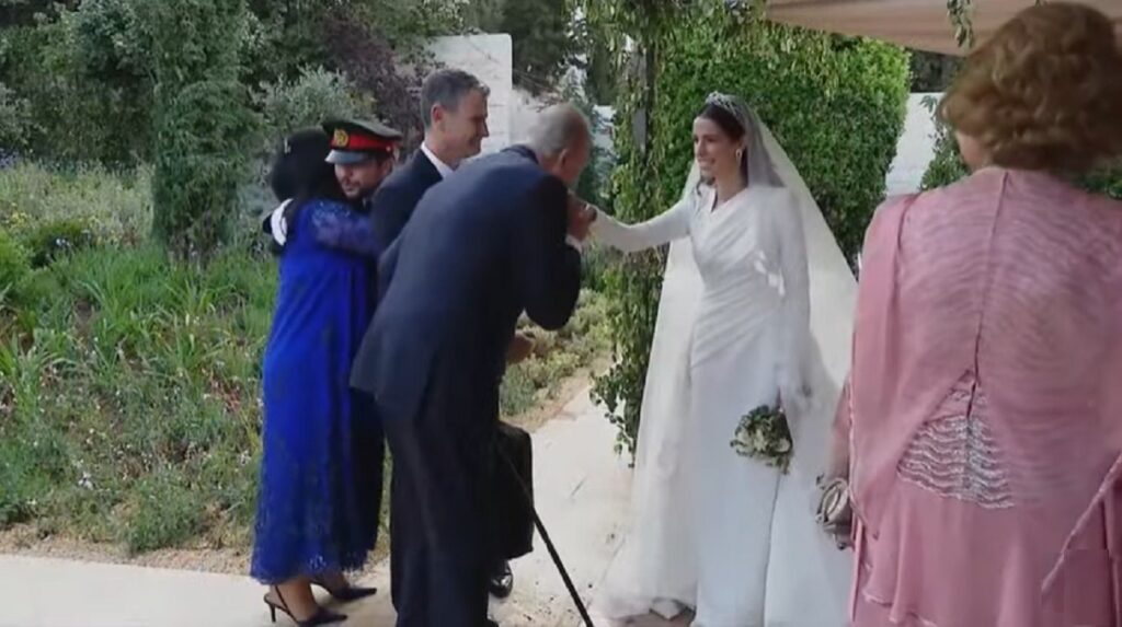 El rey Juan Carlos saluda a la novia dándole un beso en la mano