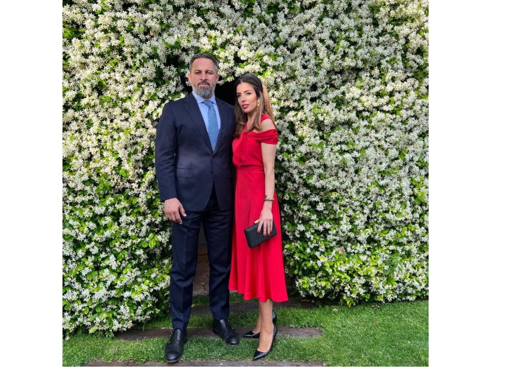 Santiago Abascal y su mujer Lidia Bedman, con vestido rojo en una boda