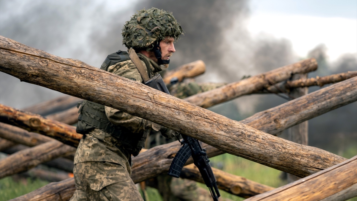 Un soldado sostiene un rifle mientras camina a través de un obstáculo hecho de vigas durante un simulacro militar encabezado por el Comandante de las Fuerzas Conjuntas de las Fuerzas Armadas de Ucrania