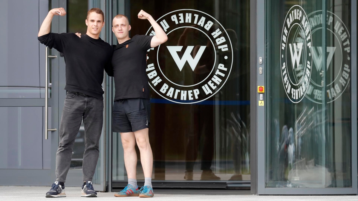 Dos hombres posan frente al edificio del Grupo Wagner en San Petersburgo