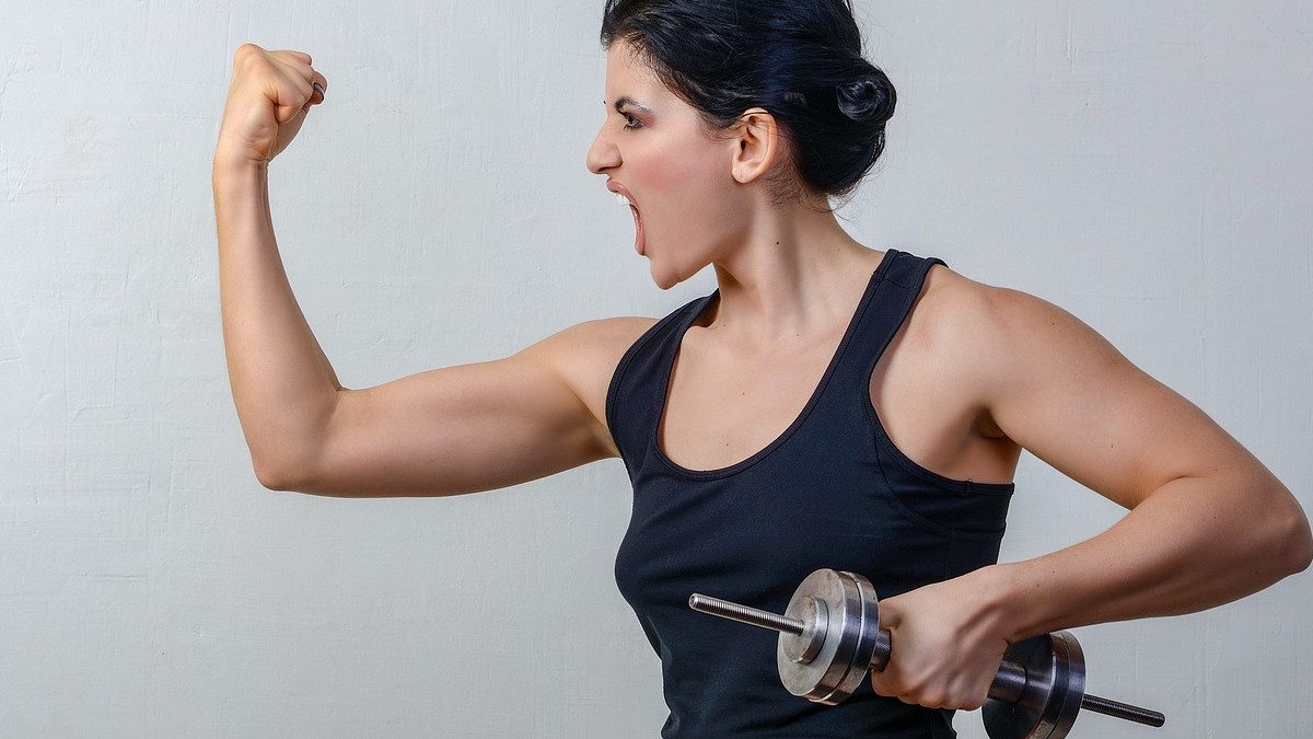 Fitness mujer en ropa deportiva entrena los músculos tríceps en