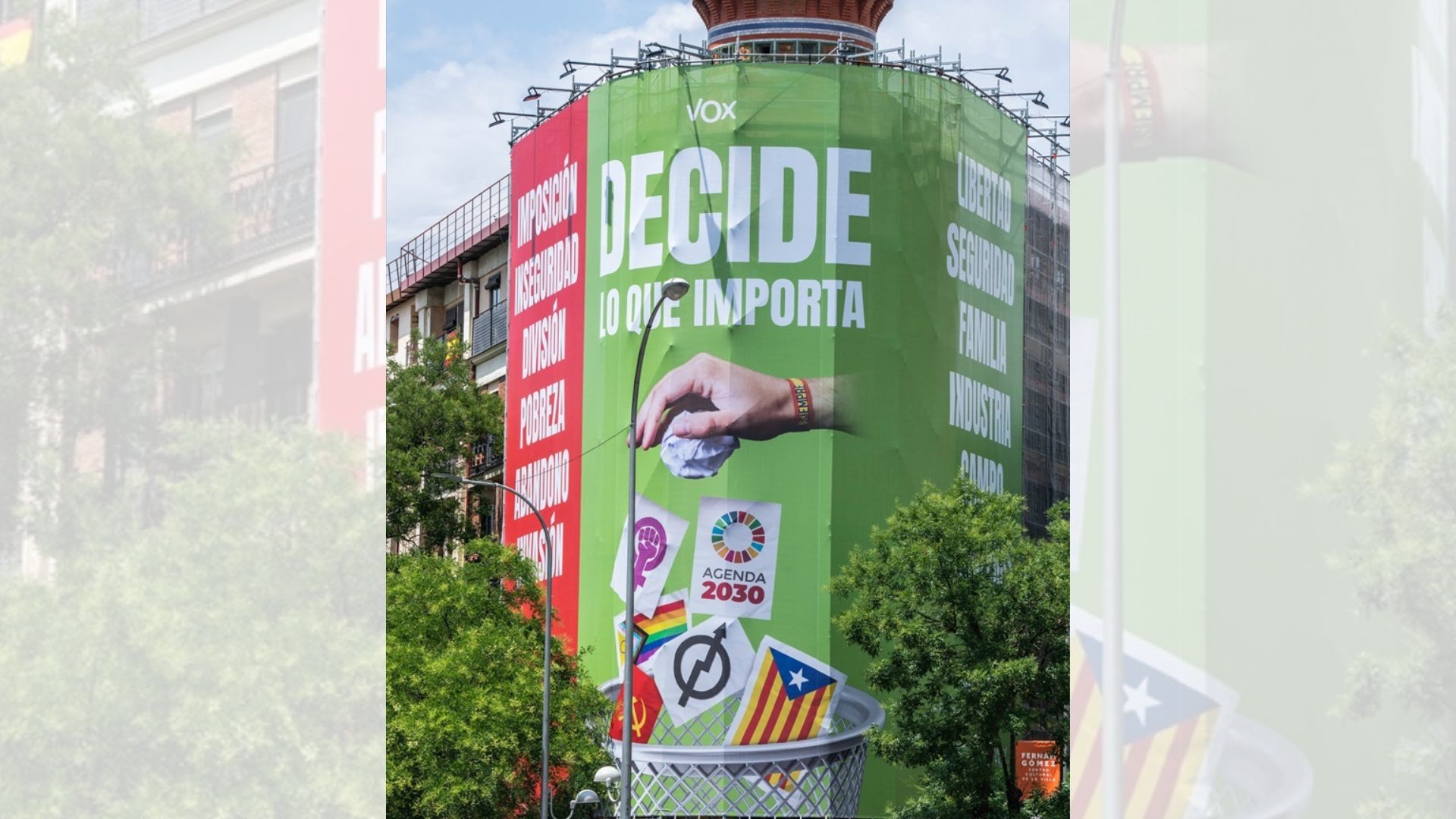 Vox despliega una lona en el centro de Madrid en la que tira a la basura la bandera LGBTI y el logo feminista