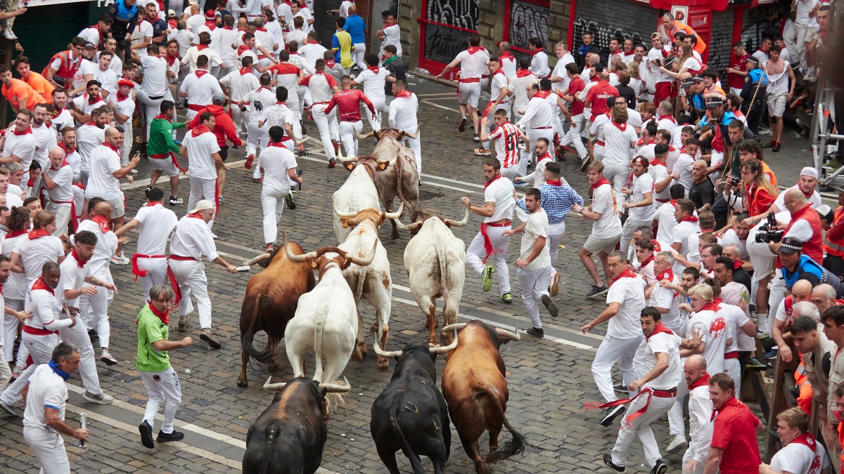 Multitud de personas corren durante el primer encierro de las Fiestas de San Fermín 2023