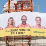 Greenpeace cuelga una lona en la Puerta de Alcalá contra los candidatos: "¿El cambio climático os la suda?"