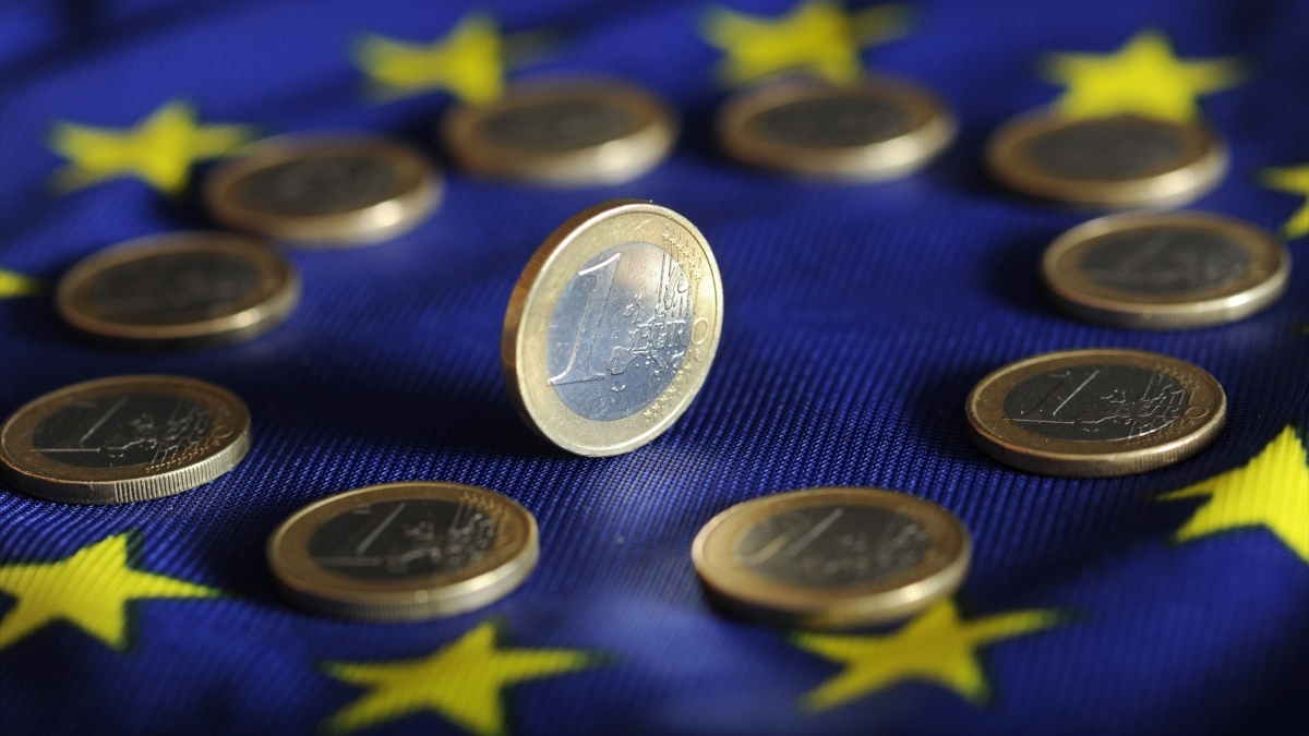Las monedas de euro se encuentran en una bandera de euro