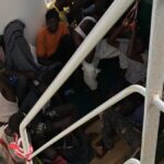Los inmigrantes rescatados se encuentran hacinados sobre la cubierta del barco mientras esperan una solución