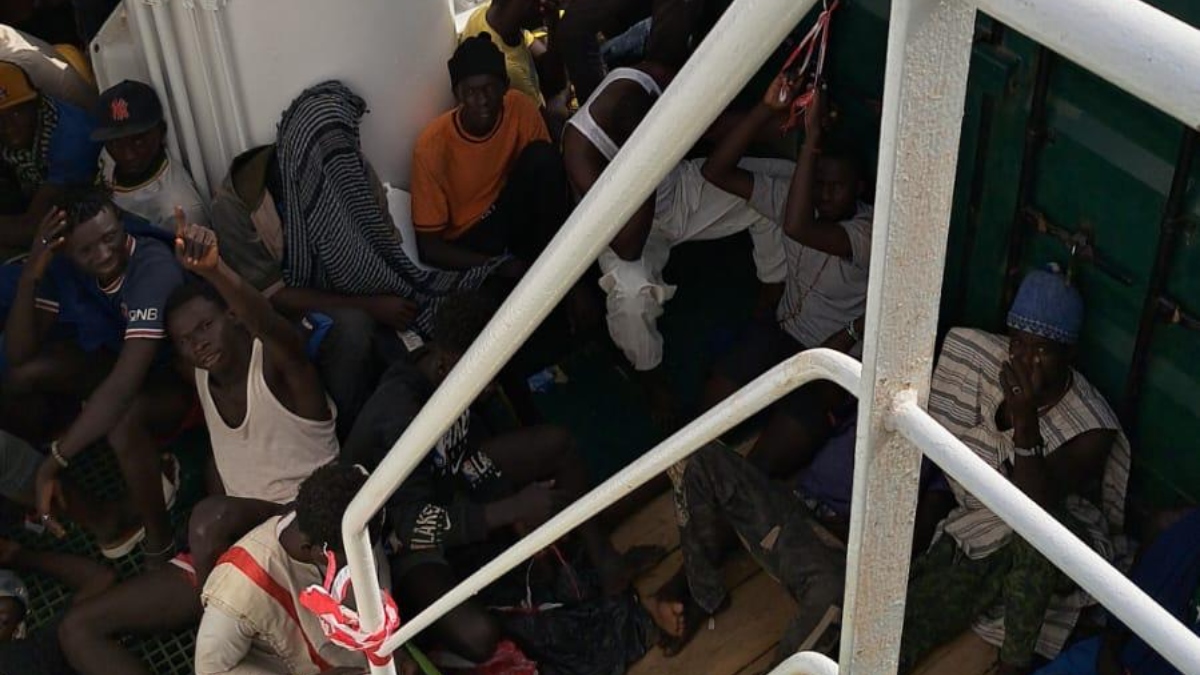Los inmigrantes rescatados se encuentran hacinados sobre la cubierta del barco mientras esperan una solución