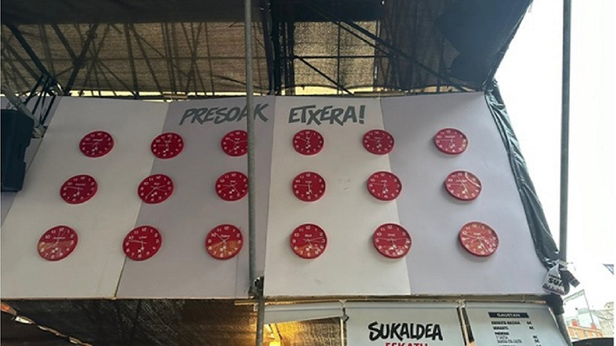 Mural con los relojes y los nombres de etarras exhibido por una comparsa en Bilbao