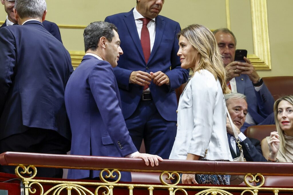 La novia de Feijóo, Eva Cárdenas, habla con Juanma Moreno Bonilla, antes de comenzar el discurso de investidura del líder del PP