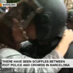 Momento en que la mujer da un beso al agente de la UIP de la Policía Nacional
