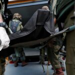 Militares israelíes recogen cuerpos en el kibutz de Kfar Aza