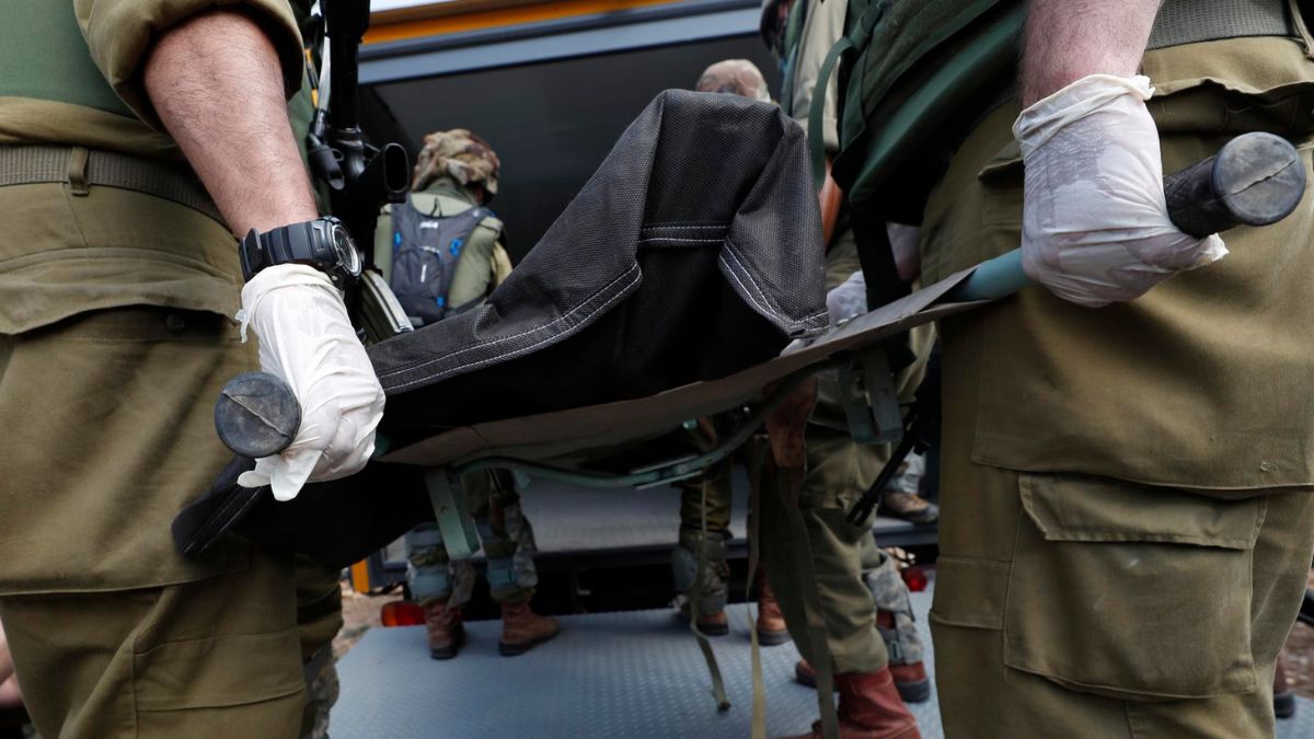 Militares israelíes recogen cuerpos en el kibutz de Kfar Aza