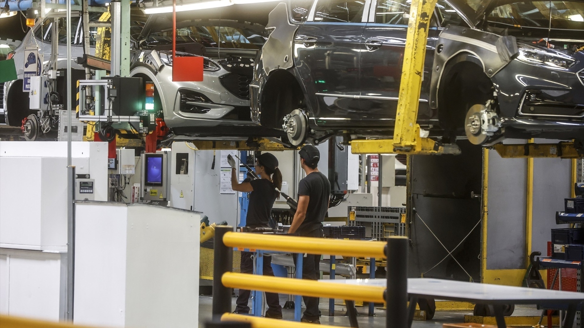 Dos trabajadores con un vehículo en la fábrica de Ford en Almussafes