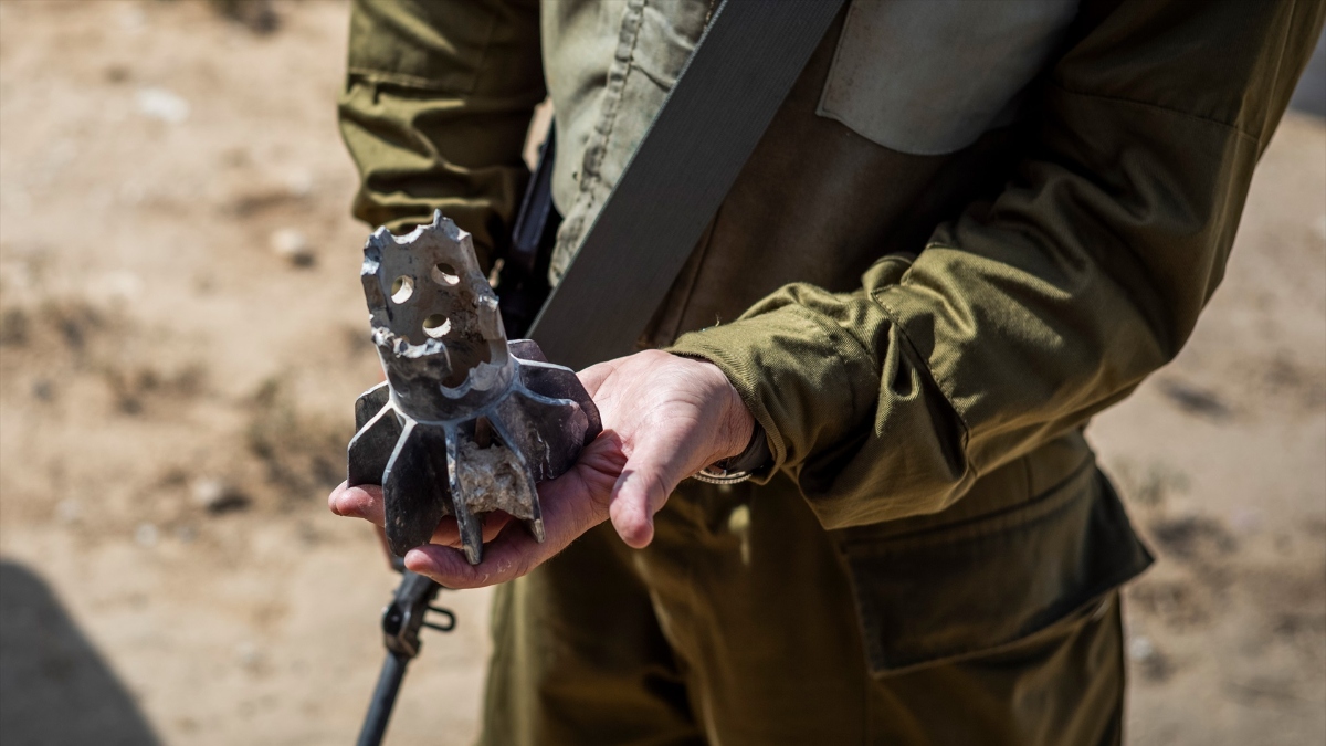 Un soldado de Israel sujetando los restos de un cohete de Hamás
