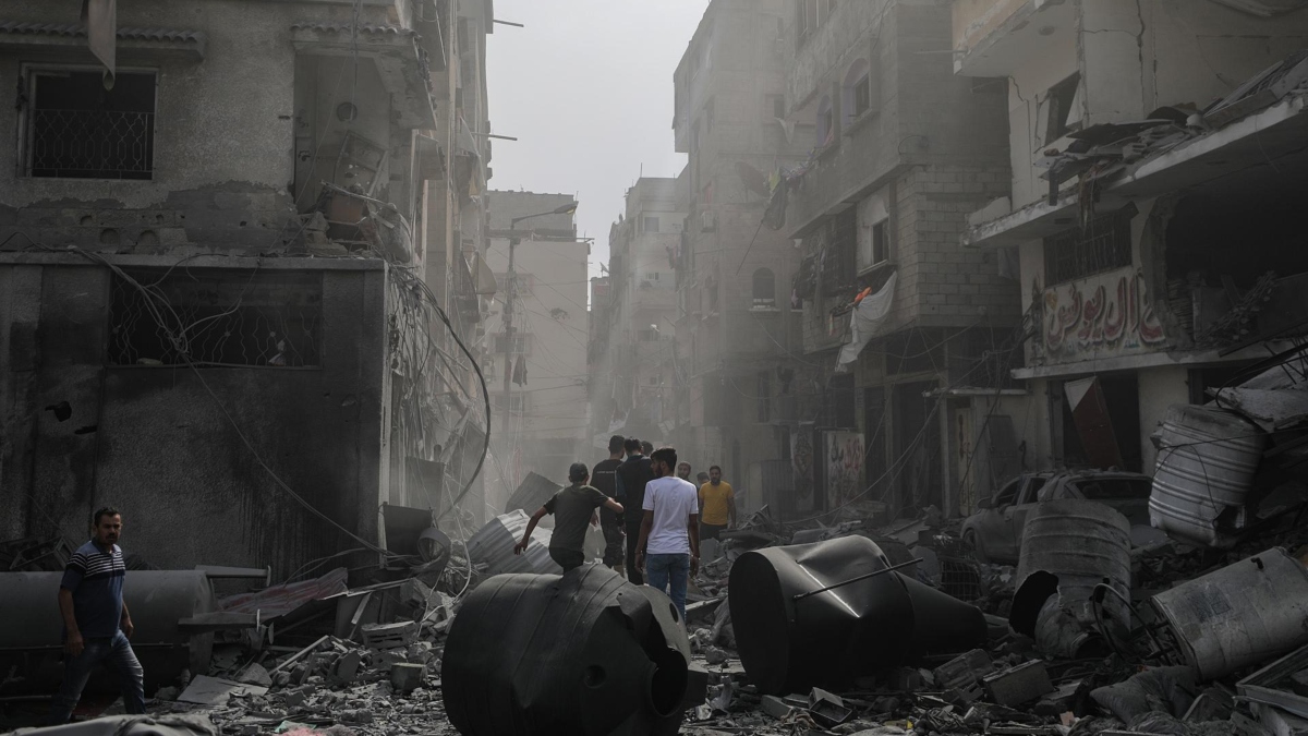 Palestinos inspeccionan una zona destruida tras los ataques aéreos israelíes en la ciudad de Gaza