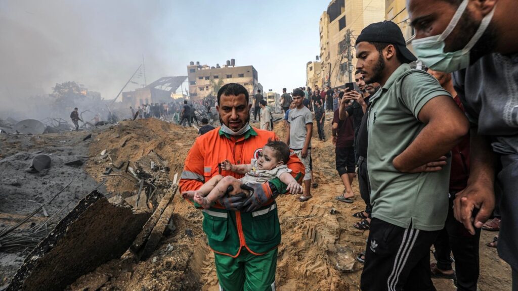 Un palestino lleva a un bebé herido que recuperó de los escombros de una zona destruida tras los ataques aéreos israelíes en la ciudad de Gaza.