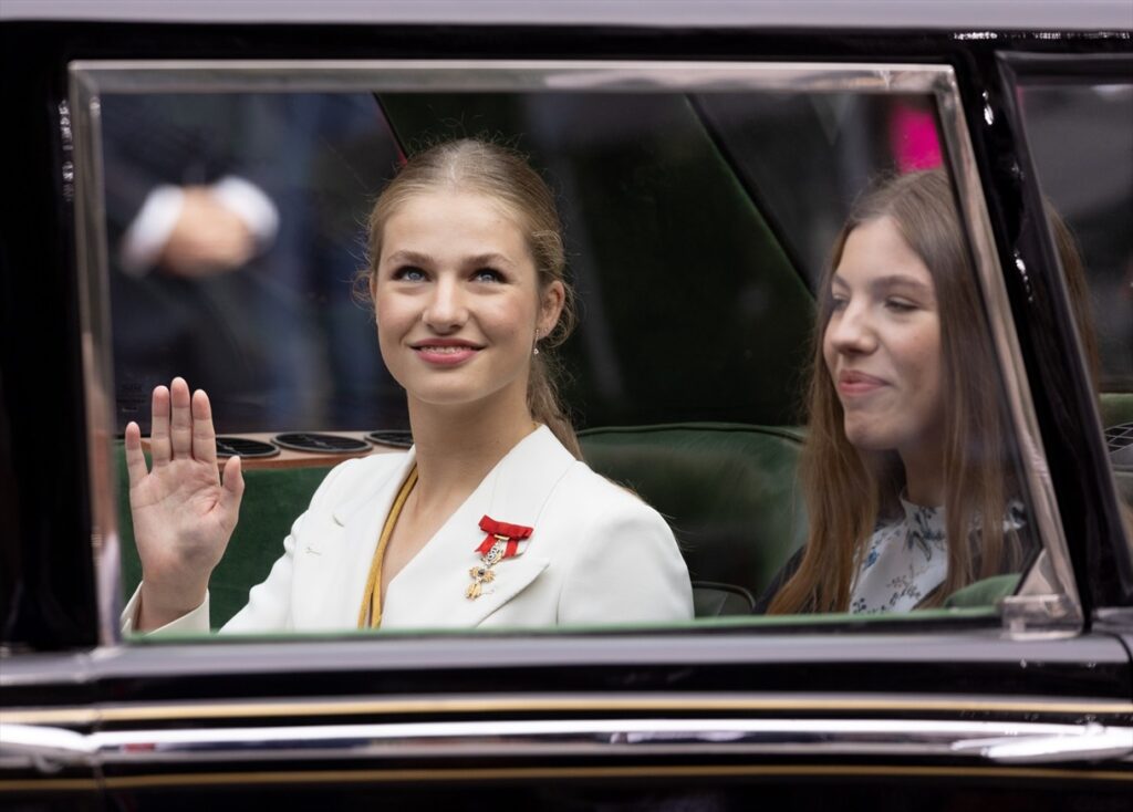 La princesa Leonor y su hermana, la infanta Sofía, saludan desde el coche
