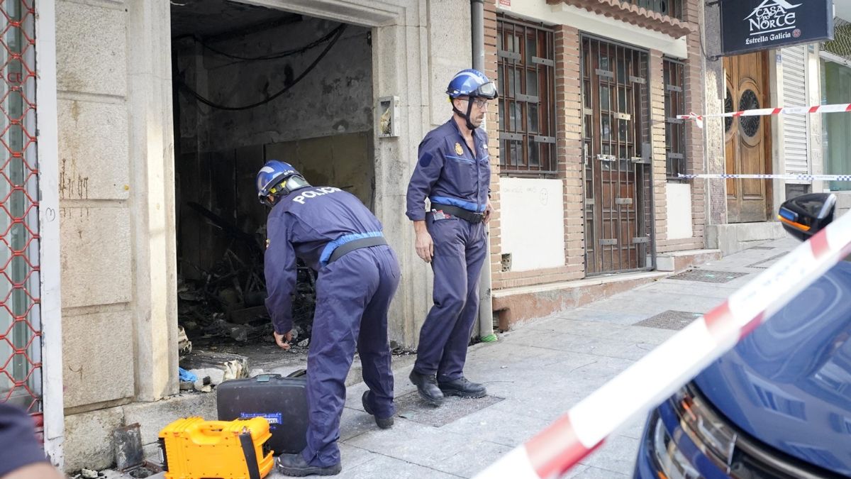 Dos agentes de policía trabajan en el edificio donde se ha producido el incendio en la calle Alfonso X el Sabio de Vigo