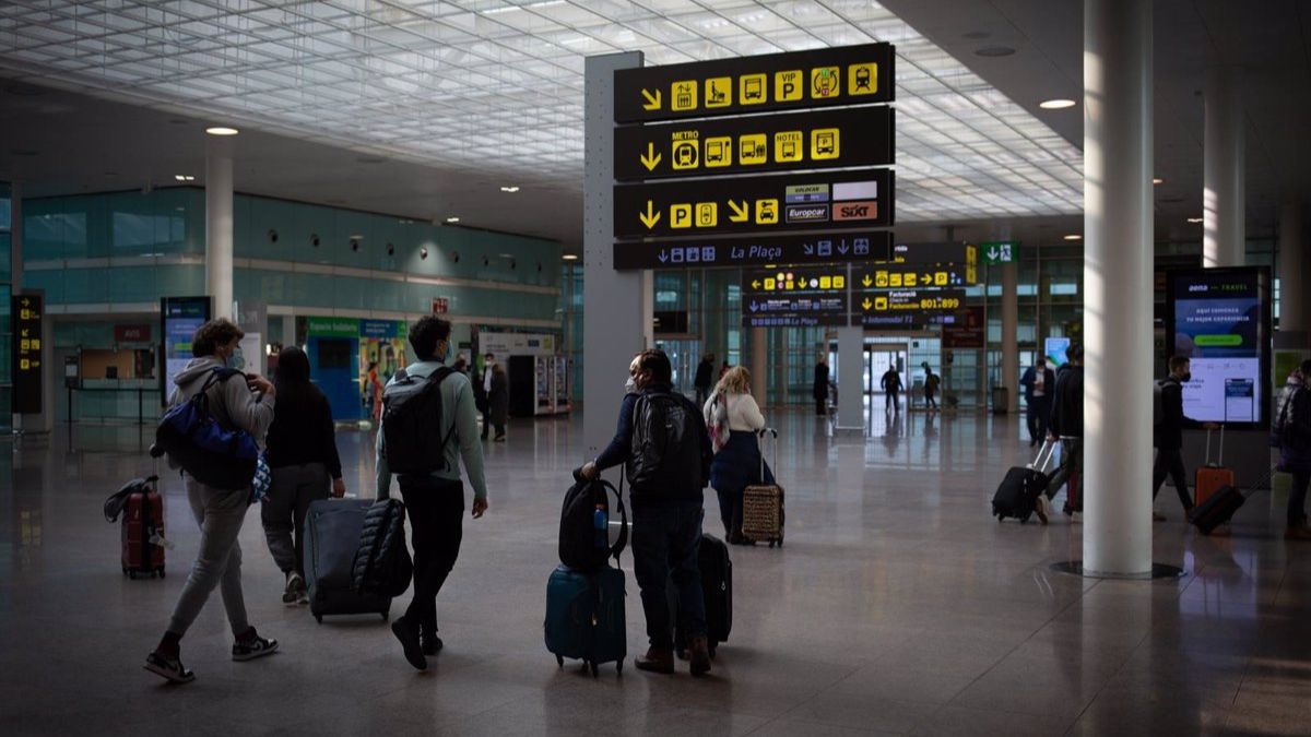 Varias personas caminan con su equipaje en el interior del Aeropuerto de Barcelona-El Prat.