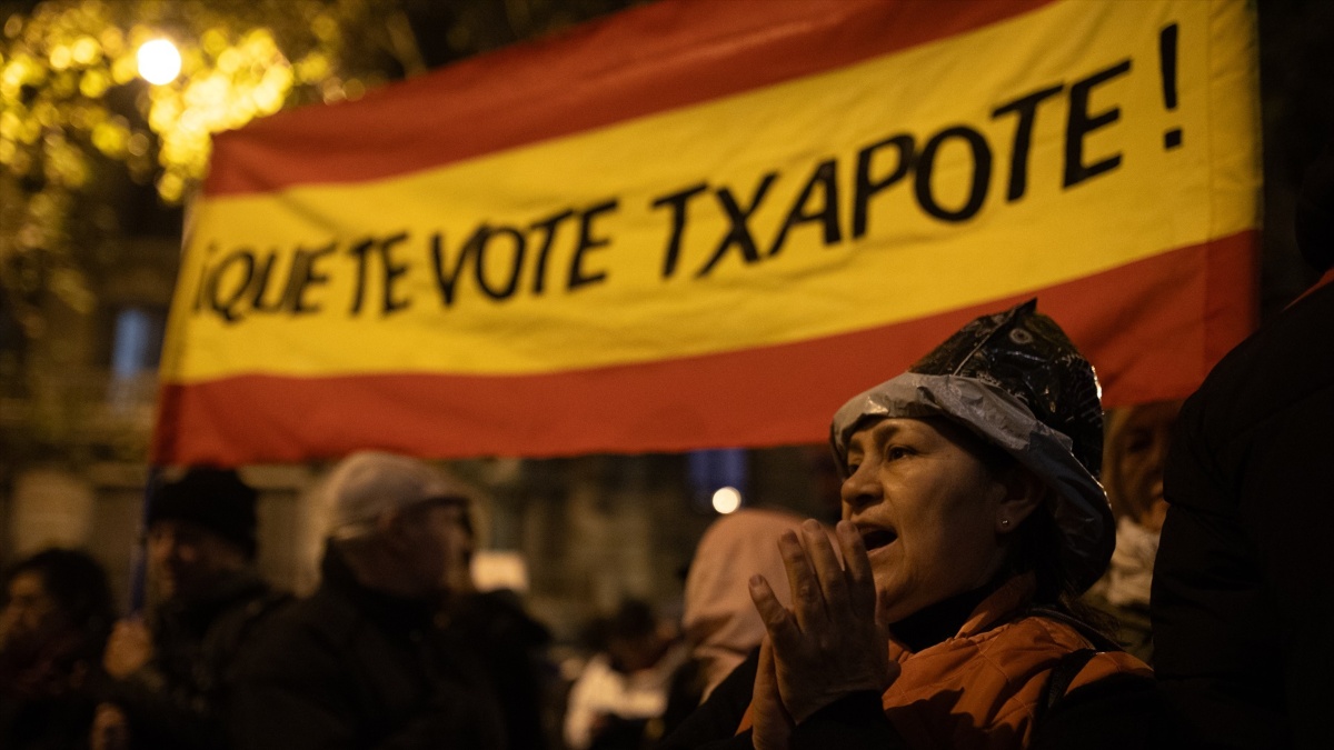 Una manifestante con la bandera de España y el texto "Que te vote Txapote", durante una protesta en la calle Ferraz