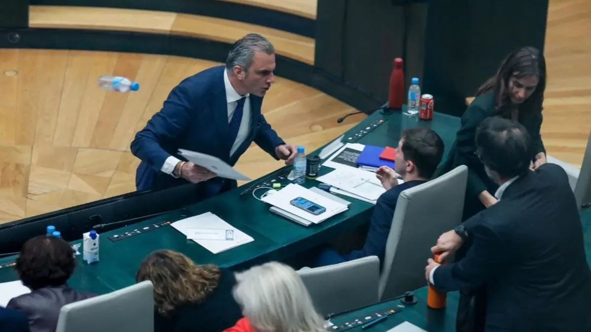 Momento en el que el portavoz de Vox en el Ayuntamiento de Madrid, Javier Ortega Smith, se encara y tira unos papeles y una botella de agua vacía al edil Eduardo Fernández Rubiño