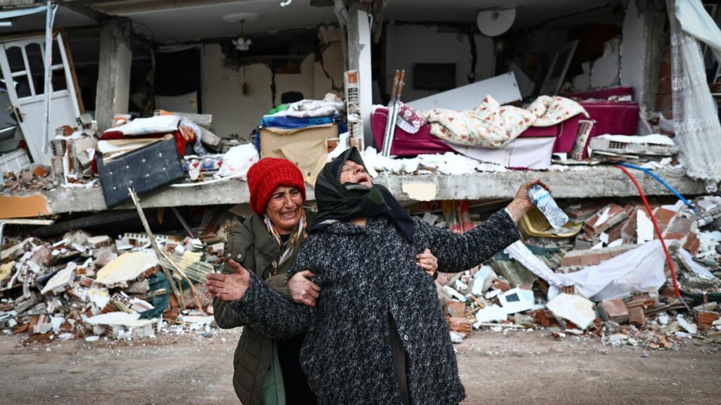 Dos mujeres lloran ante un edificio en escombros por el terremoto en Hatay, Turquía