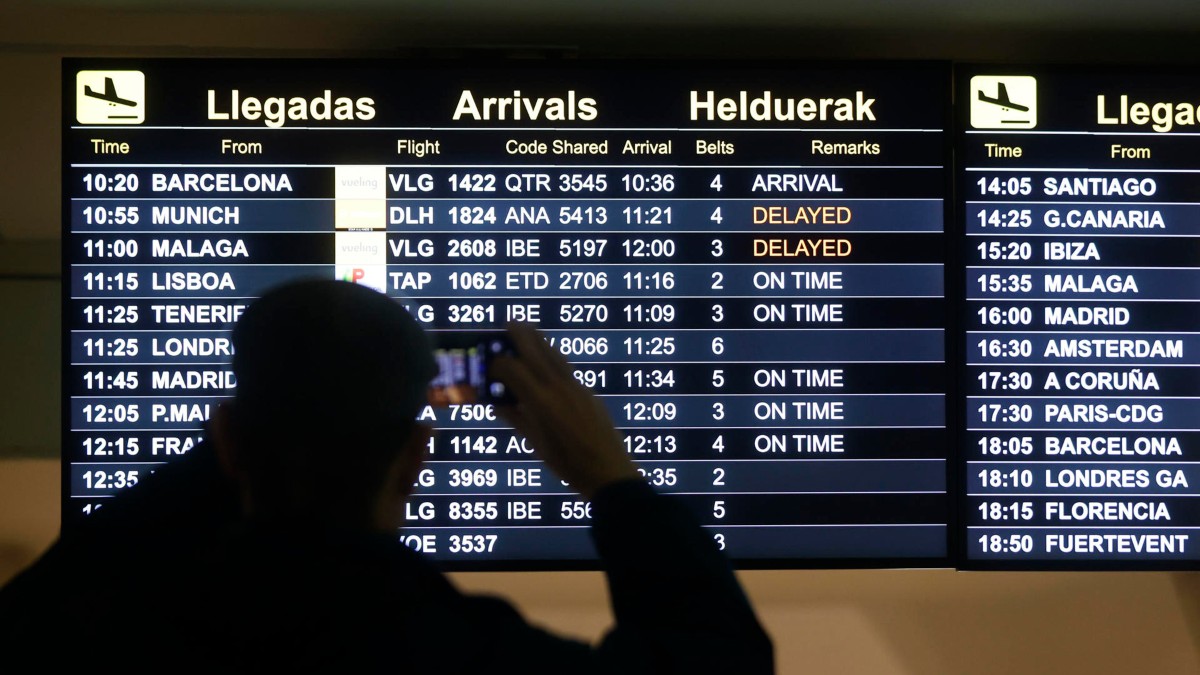 Una persona observa un panel de vuelos en el Aeropuerto de Bilbao