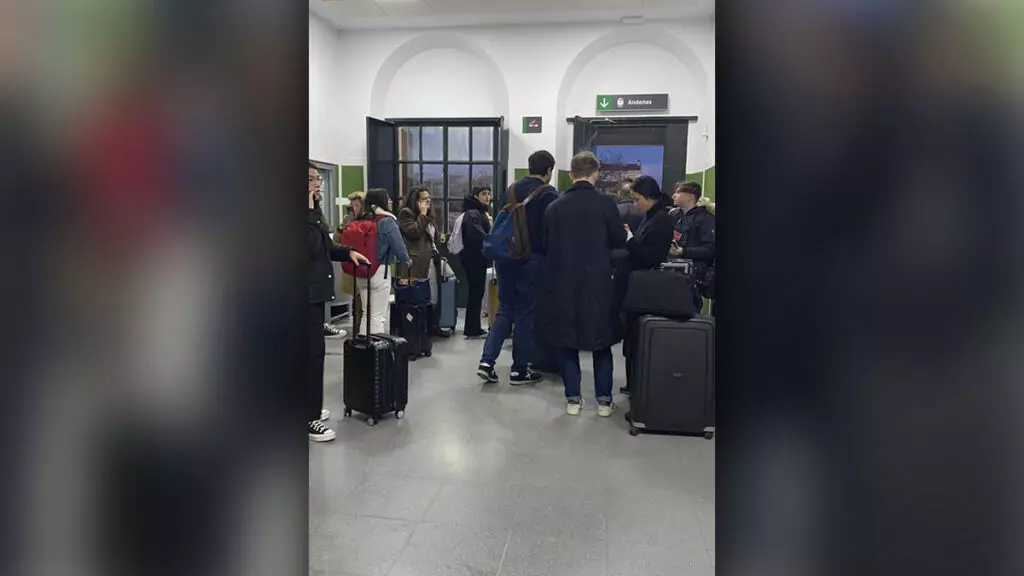 Pasajeros del tren de Extremadura averiado el 9 de febrero esperando al bus en Villanueva del Río-Minas.