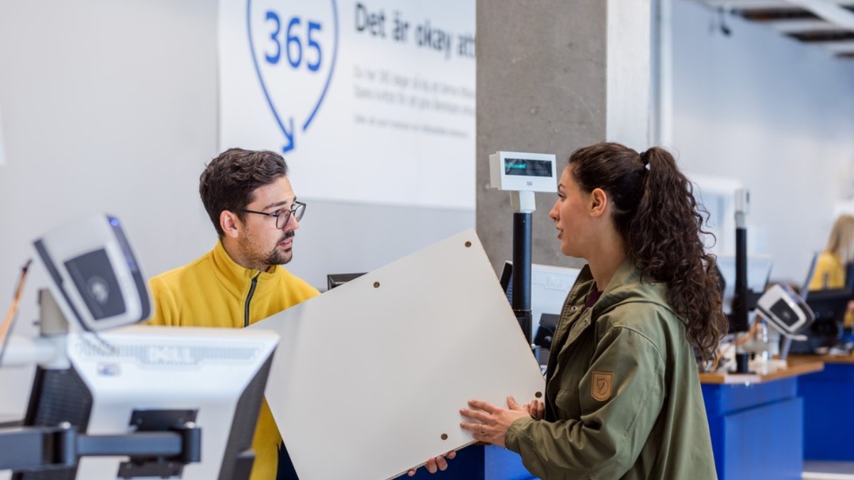 Una mujer entrega un mueble de segunda mano a un dependiente de Ikea