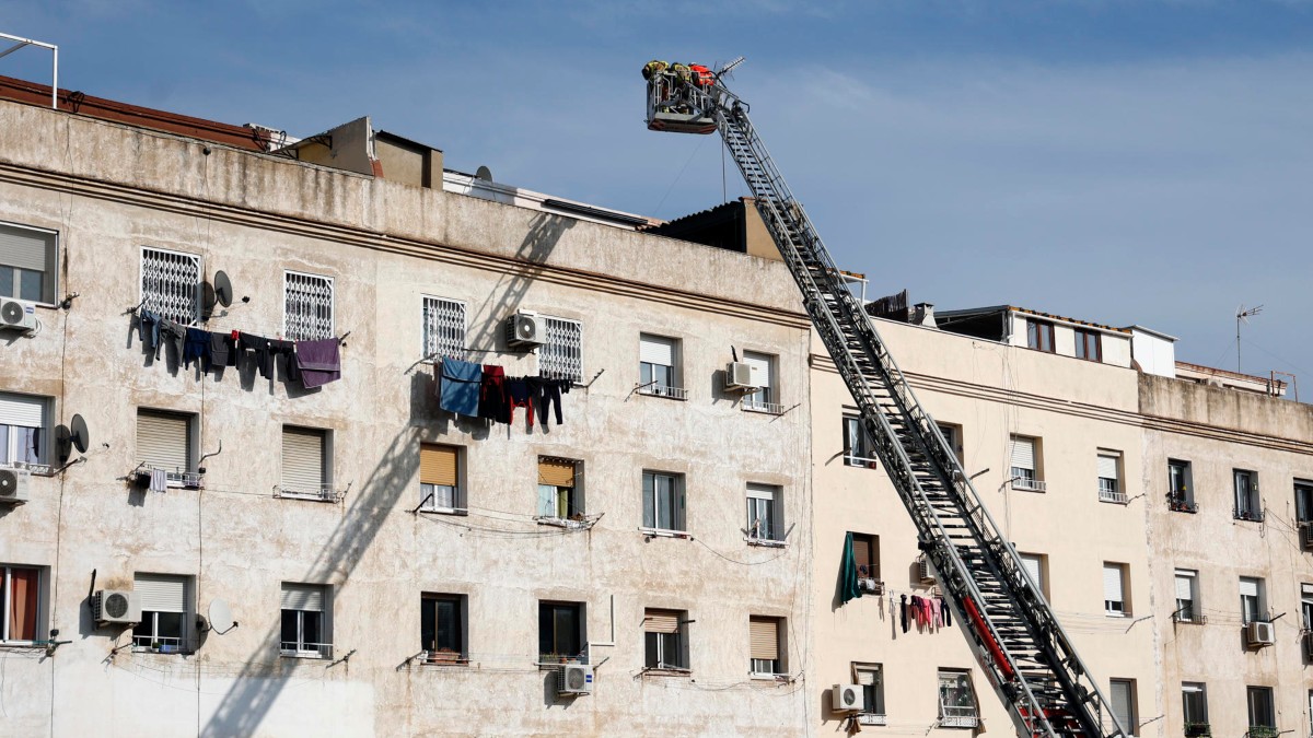 Bomberos inspeccionan el interior de un edificio derrumbado en la calle Canigó de Badalona (Barcelona)