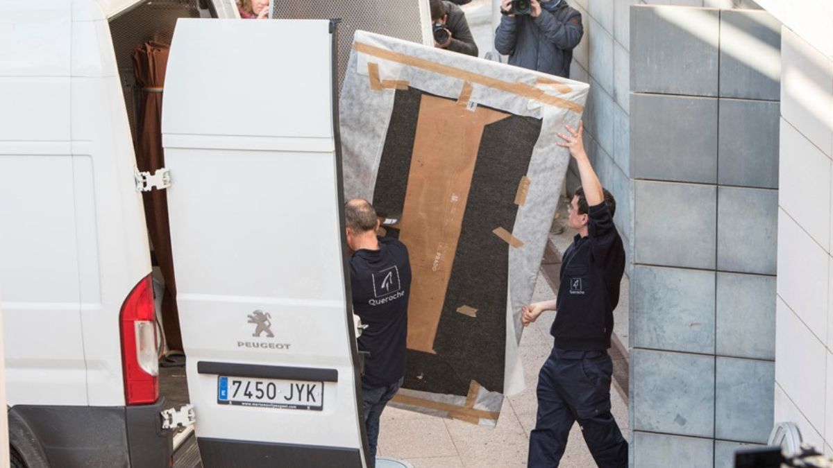 Trabajadores cargan uno de los cuadros en el Museo de Lleida que pertenecen a los bienes de Sijena